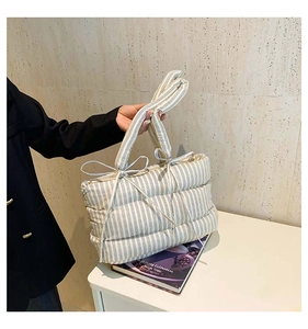 Détail du sac cabas matelassé à rayures bleues et blanches avec petits nœuds décoratifs