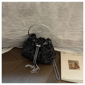 Macro shot of grey leopard print bucket bag with silver metal handle and chain drawstring