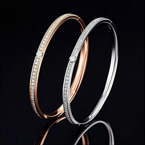 Detail of rose gold and silver hinged bangles with pavé crystals and central round stone