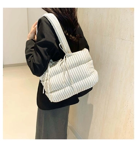 Gros plan du sac cabas rayé matelassé avec nœud latéral et texture bouffante