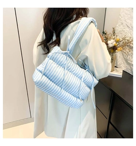 Détail du sac cabas matelassé à rayures bleues et blanches avec nœud décoratif