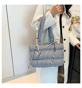 Vue latérale du sac cabas matelassé à rayures noires et blanches avec nœud décoratif