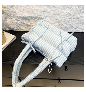 Détail du sac cabas matelassé à rayures bleues et blanches avec nœud décoratif