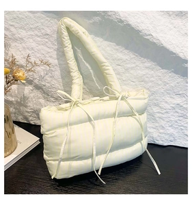 Vue détaillée du sac cabas matelassé à rayures avec nœud élégant et texture rembourrée
