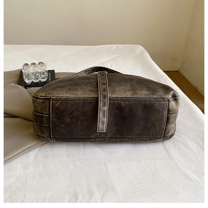 Detail view of washed vintage PU leather shoulder bag with thick decorative stitching