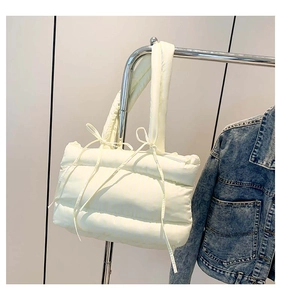 Détail du sac cabas matelassé jaune clair avec rayures verticales et nœuds rubans