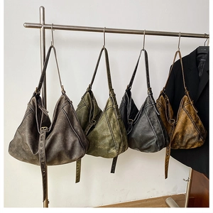 Detail of four distressed PU leather shoulder bags with metal eyelets in assorted colors