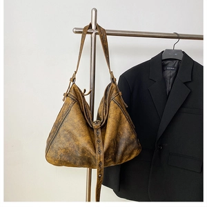 Detail of vintage caramel brown PU leather bag featuring adjustable buckle and retro texture