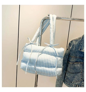 Gros plan du sac fourre-tout matelassé à rayures bleues et blanches avec nœuds décoratifs