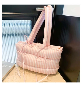 Détail du sac cabas matelassé à rayures roses et blanches avec nœuds décoratifs