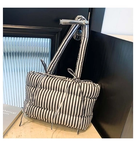 Gros plan du sac cabas matelassé à rayures avec nœud ruban sur poignée de porte noire