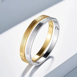 Detail of gold and silver stainless steel bangles with vintage engraved patterns