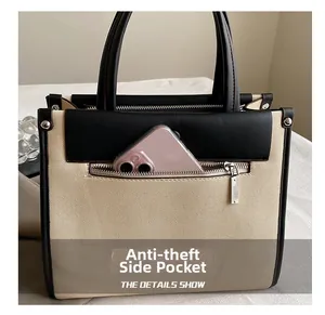Detail of a beige canvas tote with anti-theft side pocket showing phone storage