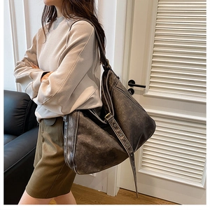 Detail of wide adjustable shoulder strap with metal eyelets on dark grey PU shoulder bag
