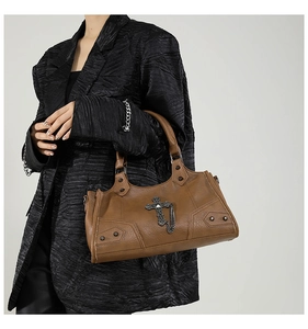 Detail der braunen Gothic-Tasche aus Kunstleder mit Metallkreuz und Nietendekor