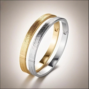 Macro shot of minimalist gold and silver bangles with detailed wave textures and clasp