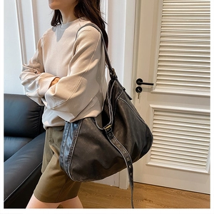 Close-up of soft washed PU leather hobo bag with vintage metal eyelets on the shoulder strap