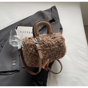 Detail shot of brown plush faux shearling textures on cylindrical Boston bag
