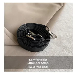 Detail of a comfortable black leather strap with silver lobster clasp on neutral fabric