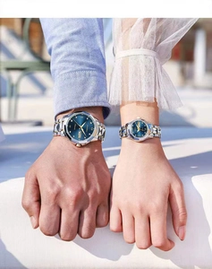 Close-up of luxury couple quartz watches with blue dials and gold-silver steel bands