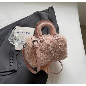 Detailed macro view of pink plush faux fur texture and smooth leather strap on a mini bag