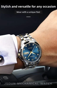 Detail of steel business watch with blue sunray dial and gold roman numerals on wrist