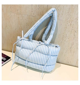 Gros plan du sac fourre-tout matelassé à rayures bleues et blanches avec cordon de serrage