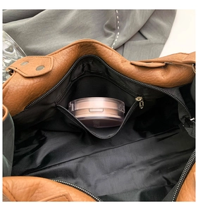 Innenansicht der karamellbraunen Ledertasche mit schwarzem Futter und Reißverschluss
