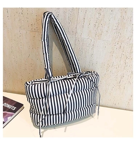 Détail d'un sac cabas rembourré à rayures verticales noires et blanches avec nœuds