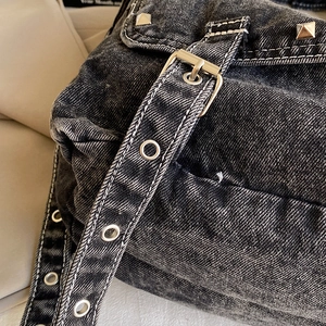 Retro distressed denim tote bag with metal rivets and adjustable buckle strap details