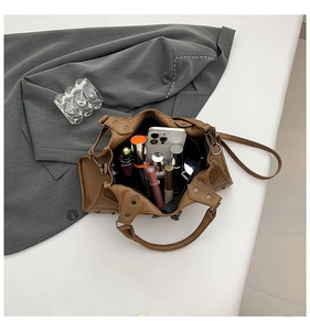 Detailansicht des geräumigen Innenraums einer braunen Punk-Handtasche mit Nieten