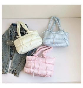 Vue détaillée de sacs cabas matelassés en jaune, bleu et rose avec des nœuds doux