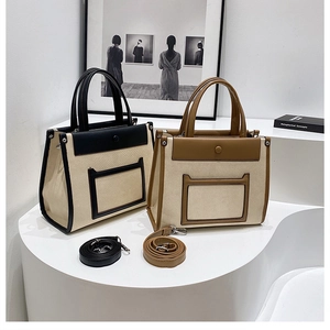 Detail of two-tone canvas tote bags with adjustable straps in black and brown trims