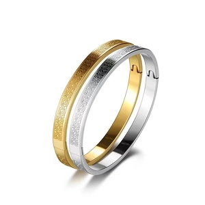 Coppia di bracciali in acciaio inossidabile oro e argento con motivo geometrico inciso