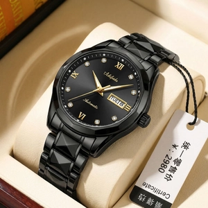Close-up of black automatic watch with gold markers in a premium leather gift box