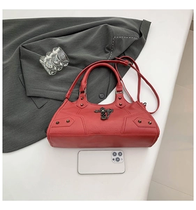 Detail der roten Punk-Lederhandtasche mit schwarzem Gothic-Kreuz und Nietenbesatz