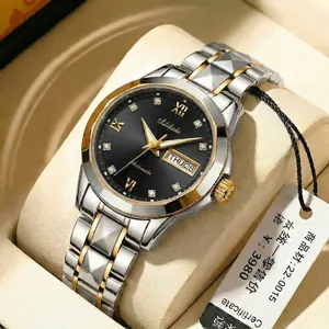 Detail of steel strap watch with black sunray dial and day-date display on pillow