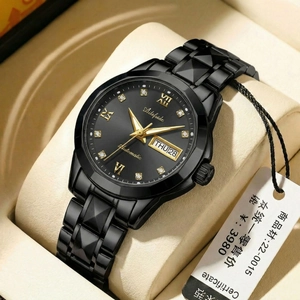 Sleek black stainless steel business watch with gold accents and date display on a cushion