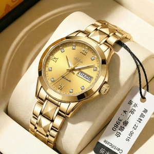 Macro detail of gold watch dial with date display on beige velvet watch cushion