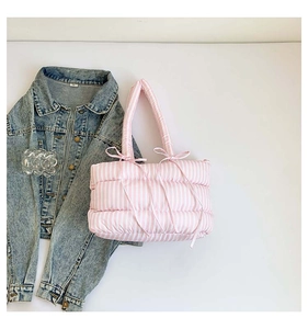 Vue détaillée du sac cabas matelassé à rayures roses et blanches avec nœud décoratif