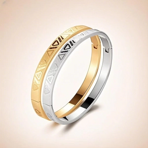 Detailed close-up of geometric triangle carvings on gold and silver stainless steel bangles