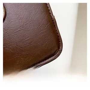 Close-up of premium dark brown lychee grain leather with fine stitching details