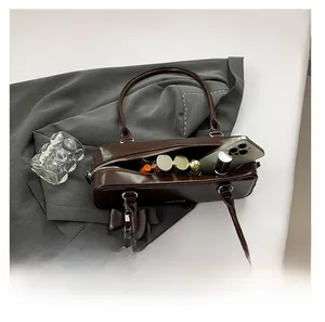 Detail view showing spacious interior of dark brown baguette bag with leather bow charm