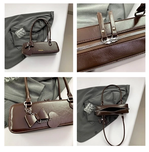 Detail view of coffee baguette bag showing zip hardware, bow charm and interior