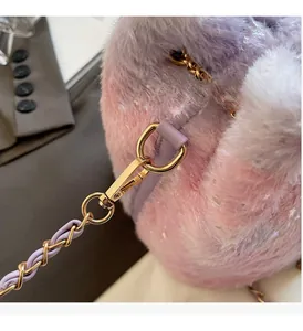 Detail of plush faux fox fur bucket bag with gradient pink-purple texture and gold chain