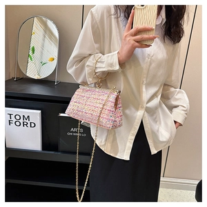 Detail of pink sequin tweed handbag with gold ring handle and chain strap on model