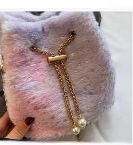 Detail of pink and purple plush bucket bag with silver stars and golden chain drawstring