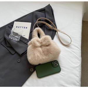 Close-up of cute plush bunny ear bucket bag in beige with adjustable leather strap