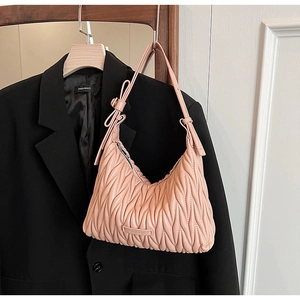 Close-up of pink pleated texture and bow detail on stylish hobo shoulder bag for women