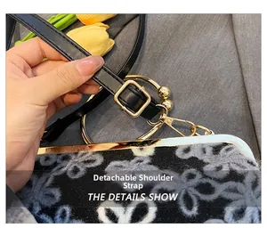 Détail du sac de soirée floral noir et blanc avec bandoulière en cuir amovible